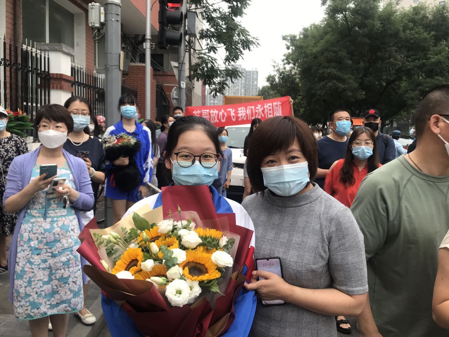 一零九中学考点门口，杨女士站在人群最前面，抱着鲜花迎接女儿。 新京报记者 冯琪 摄