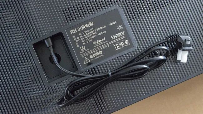 背板左侧是产品信息和电源线,小米电视 大师65"oled采用的是一体式的