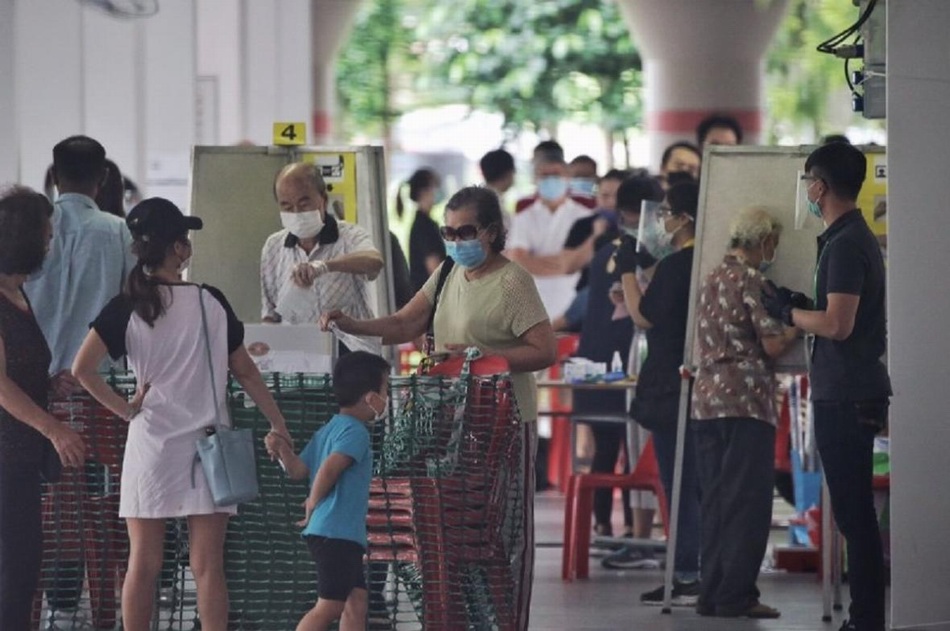 7月10日，人们在新加坡一处投票站戴着手套投票。 