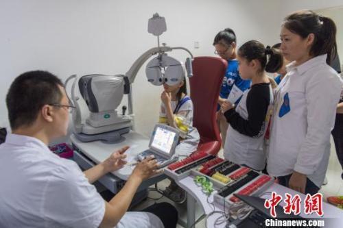 资料图：中小学生在家长的陪同下检查视力。韦亮 摄