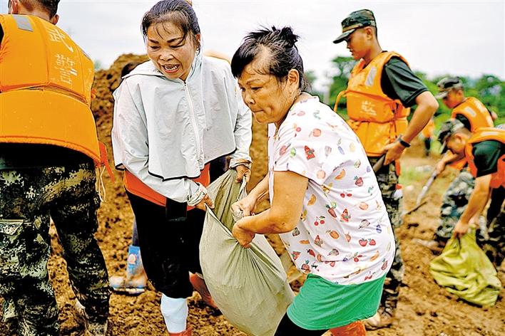 7月11日,在鄱阳镇江家岭村"阿姨团"成员江云风(前)和余风英在圩堤