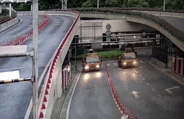 图说:被告人酒后驾驶牵引车(左)撞毁外滩隧道入口处限高杆.