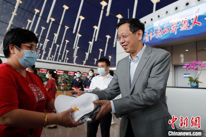 东航集团副总经理席晟向旅客赠送礼物. 殷立勤 摄