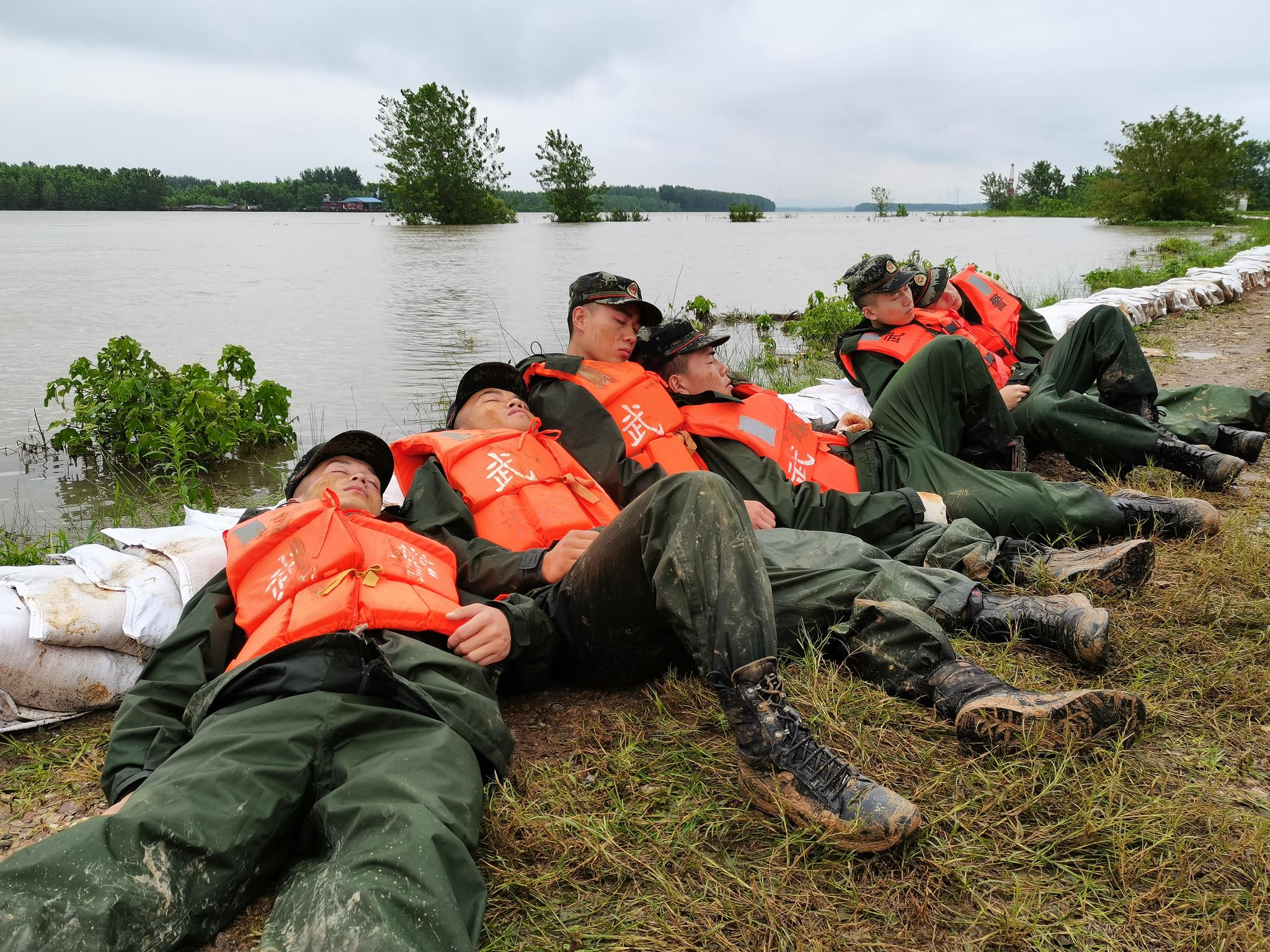 【防汛救灾第一线】 抗洪一线的武警:在雨中进食,累了就躺在堤坝上