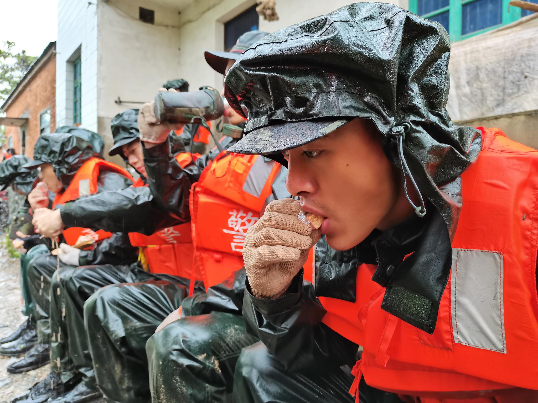 【防汛救灾第一线】 抗洪一线的武警:在雨中进食,累了就躺在堤坝上