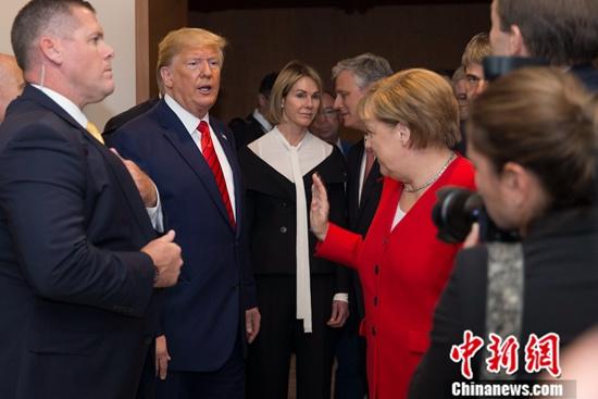 资料图:美国总统特朗普与德国总理默克尔进行交流。中新社记者 廖攀 摄