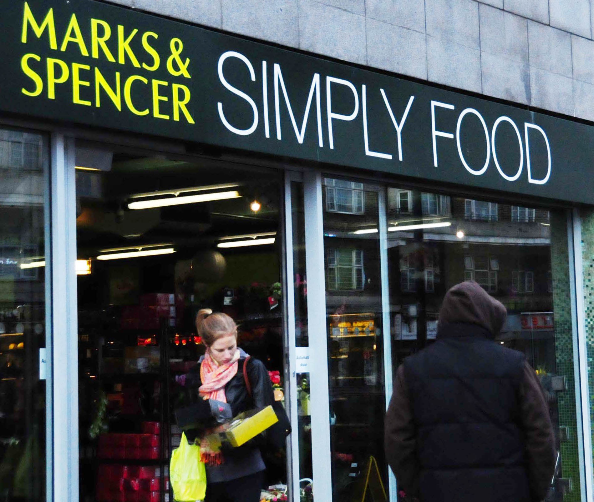 图片是2009年1月7日,行人从英国首都伦敦街头的一家玛莎食品店门前