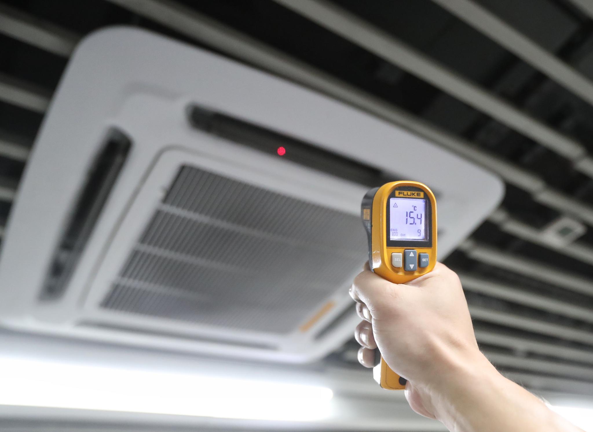 红外线测温仪显示,空调出风口的温度为15.4℃.摄影/新京报记者 王贵彬