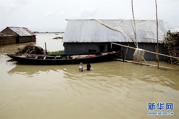 7月19日，在距离孟加拉国首都达卡100多公里的福里德布尔，当地居民的房屋淹没在洪水中。 孟加拉国境内地势低洼，河流密布。每年6月至9月的季风雨季，洪涝灾害经常发生。 新华社发