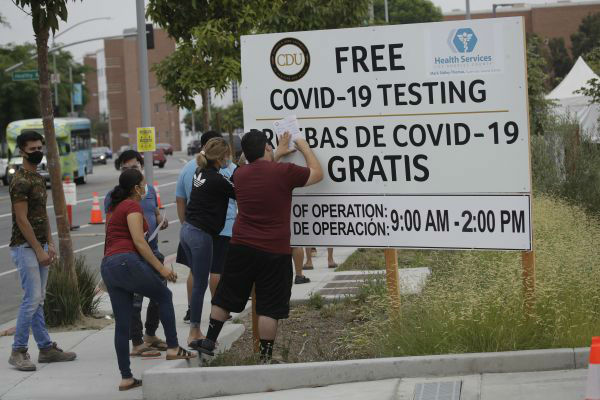 7月22日，在美国加利福尼亚州洛杉矶一处新冠病毒检测点，人们填写表格。新华社/美联