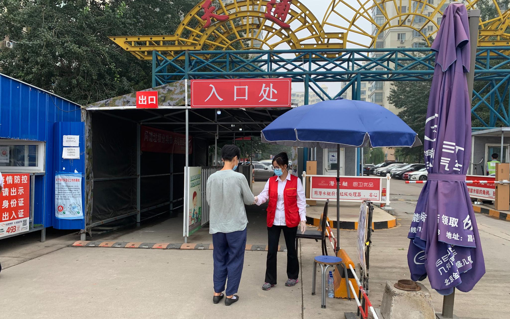 天通苑西三社区门口,居民接受测温进入小区.摄影/新京报记者 姜慧梓