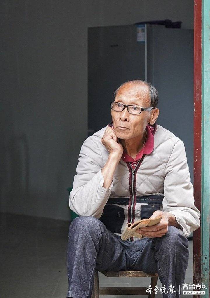 老人手拿古书,边看边思考