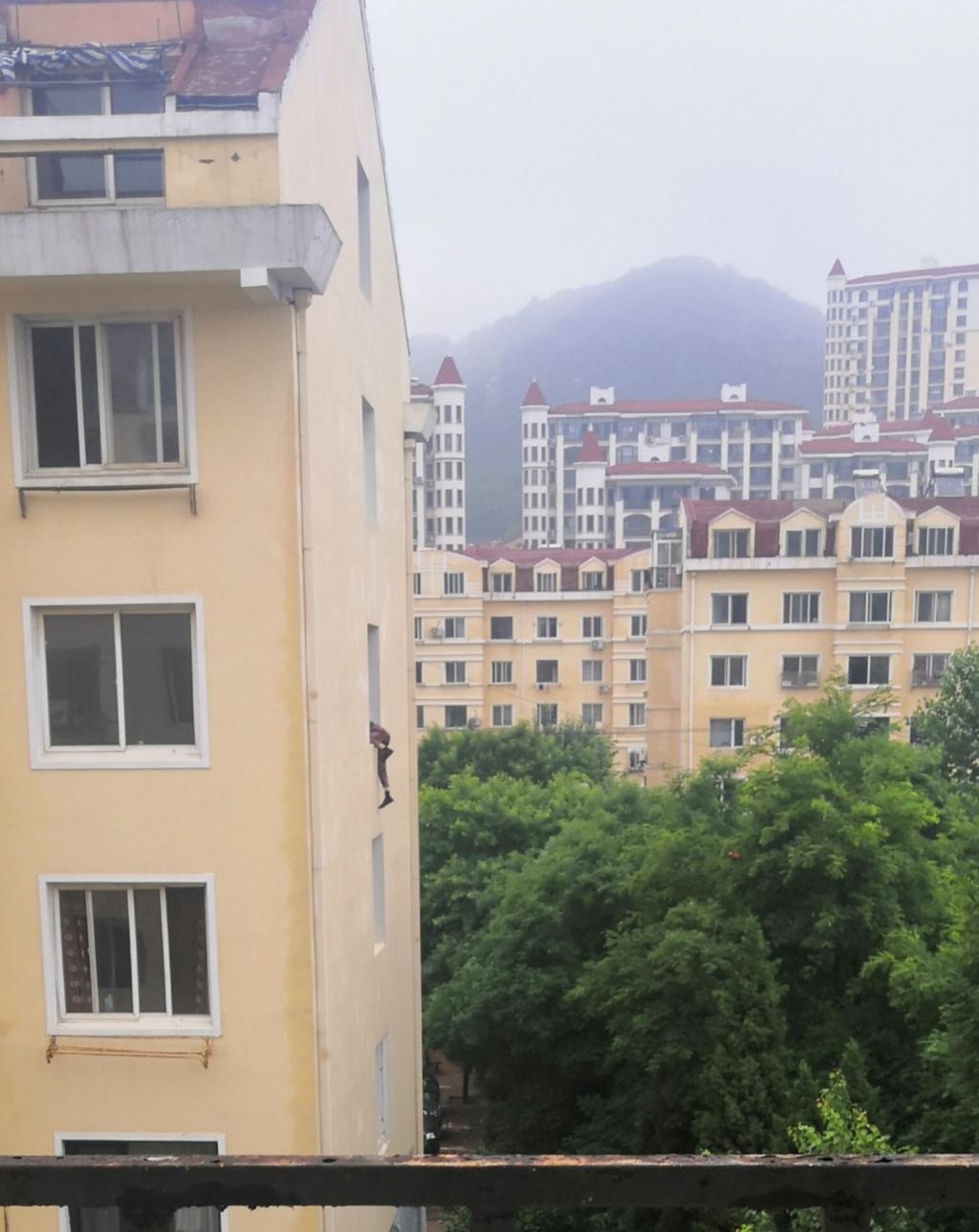 对面楼有人下身悬在4楼窗外,女孩慌忙报警