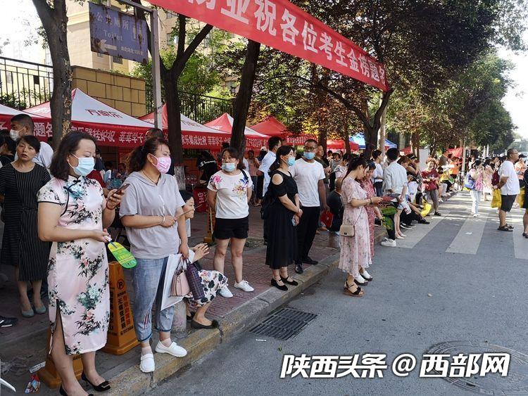 早上9点，在宝鸡市斗鸡中学考点，前来送考的学生家长依旧在考点守候着。不少考生家长旗袍装，寓意“旗开得胜”。