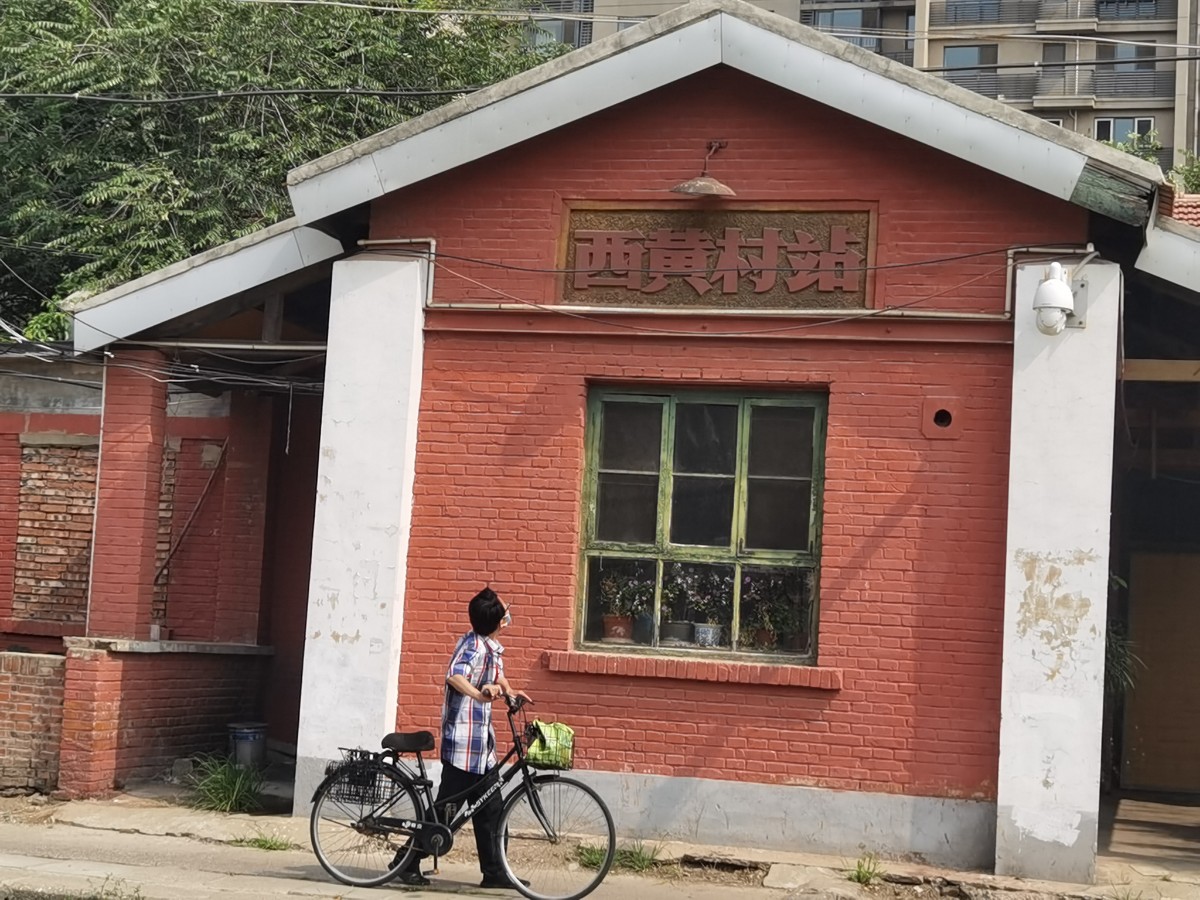 7月8日,市民从石景山区西黄村车站前面通过.