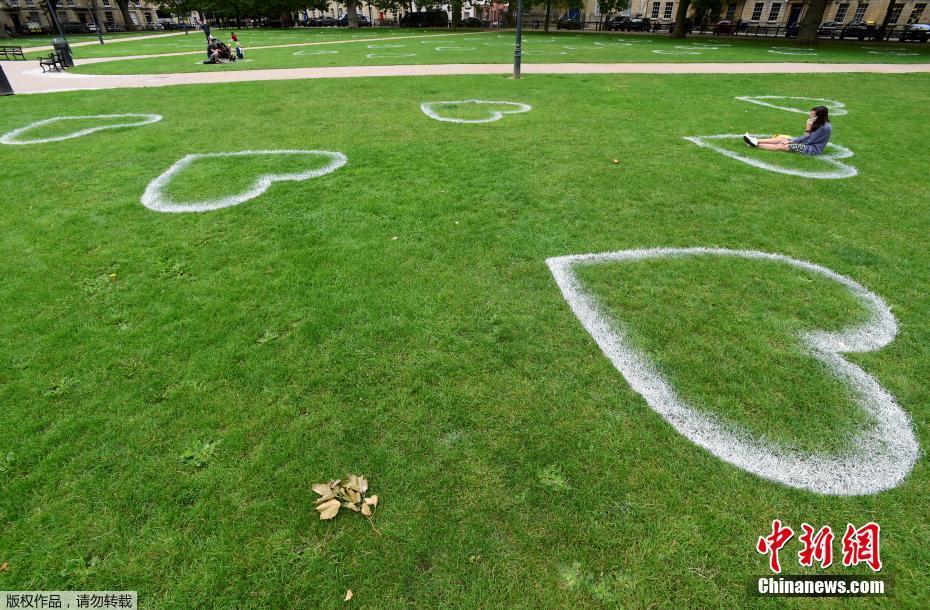 英国艺术家草地上画心敦促保持距离 变成浪漫约会地