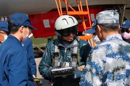 空軍航空兵某旅副參謀長姚凱(中)向機務官兵反映飛機使用情況(2020年2