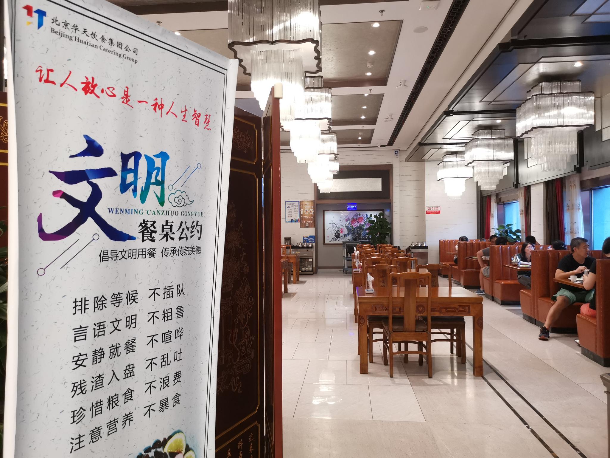  华天老字号餐厅门口都有“文明餐桌公约”，其中提示“珍惜粮食，不浪费”。新京报记者 吴宁 摄