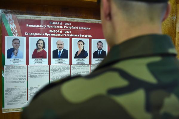 资料图片：8月9日，在白俄罗斯明斯克一处投票站，一名军人阅读候选人信息，包括卢卡申科在内的5名候选人参加了竞选。（新华社/法新）