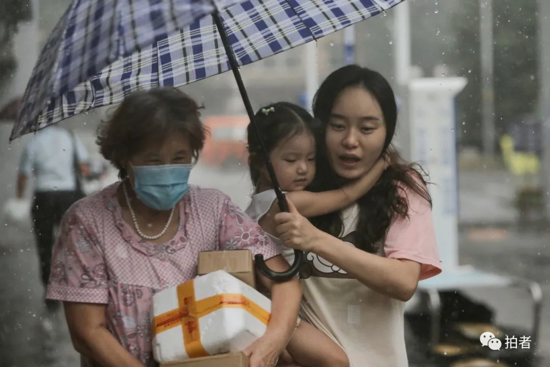 △ 复兴路，小女孩紧紧抱在打伞家长的怀中。摄影/新京报记者郑新洽
