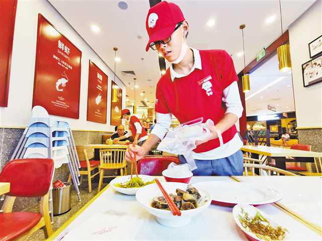 8月11日，江北区石马河龙湖源著天街某水饺店，服务员为顾客将剩余的菜品打包。图片由首席记者崔力摄 视觉重庆