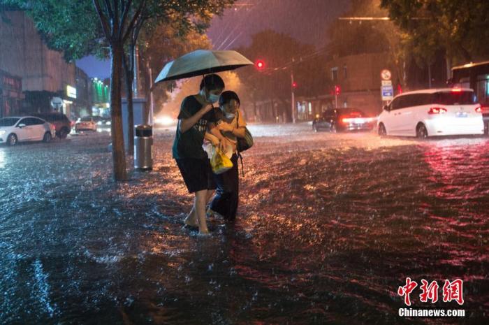 资料图：8月9日晚，北京市民冒雨涉水出行。当日，北京气象台发布18时至23时降水量(毫米)：全市平均17.9，城区平均28.1。 中新社记者 田雨昊 摄