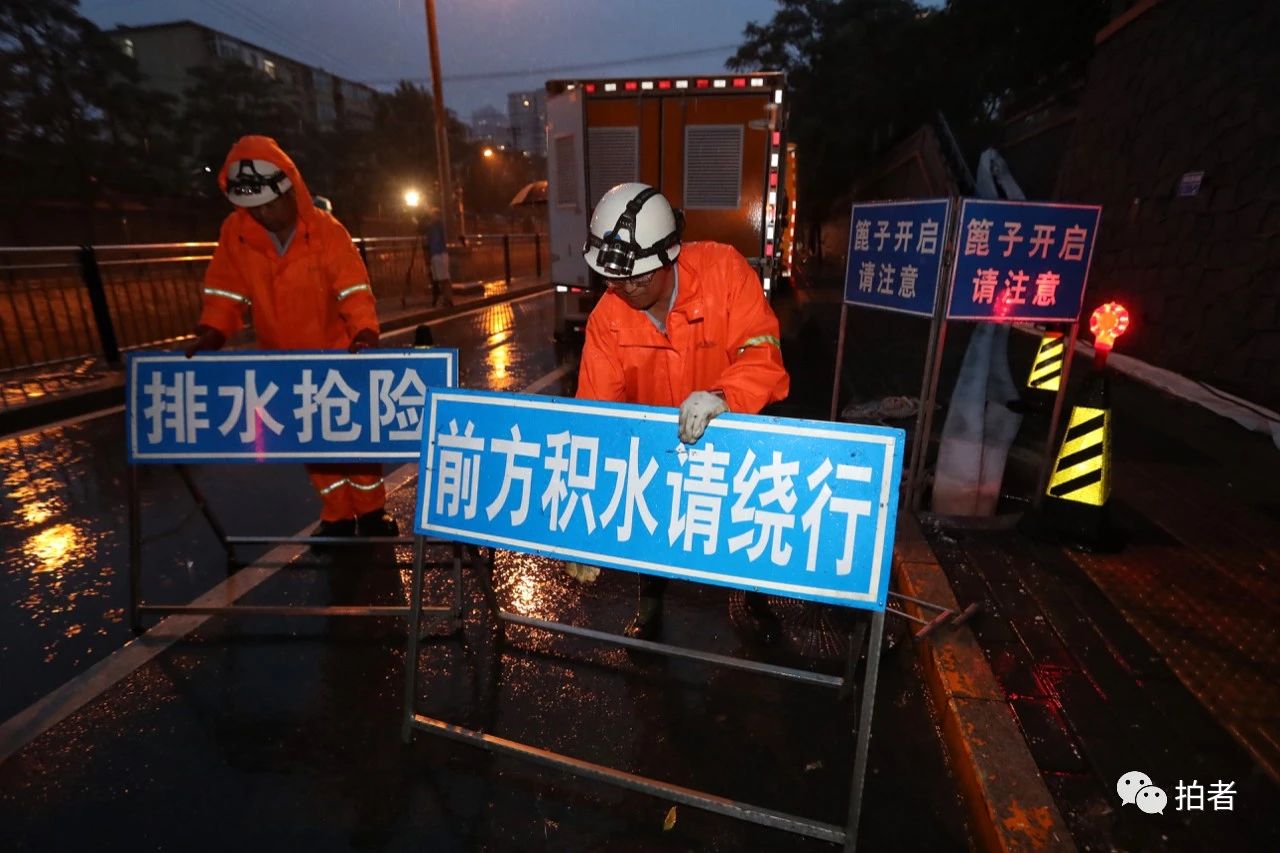  △ 18时30分前后，北京朝阳区雨势增大，在西大望路附近，20分钟左右路边就出现了积水。工作人员摆放排水抢险提示牌。摄影/新京报记者王贵彬
