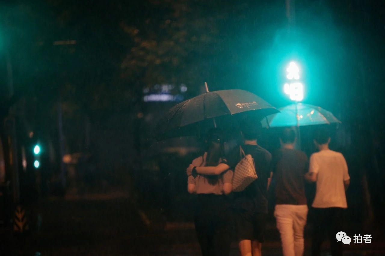 △ 苏州街，搂在一起撑伞过马路的行人。摄影/新京报记者郑新洽