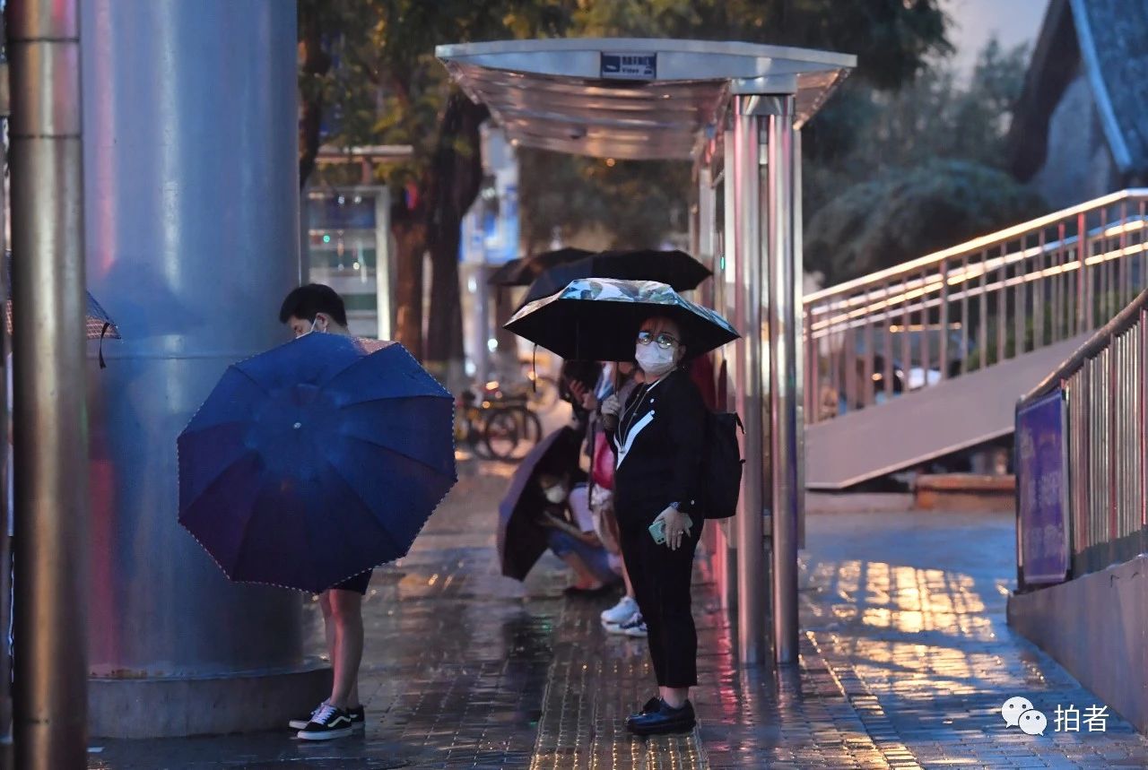  △ 东四十条桥西公交站附近，在过街桥下避雨的市民。摄影/新京报记者李木易