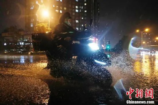 北京朝阳区，外卖小哥冒雨送餐。中新社记者 韩海丹 摄