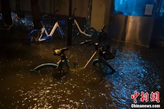 北京市西城区，共享单车侵泡在积水中。中新网记者 李骏 摄
