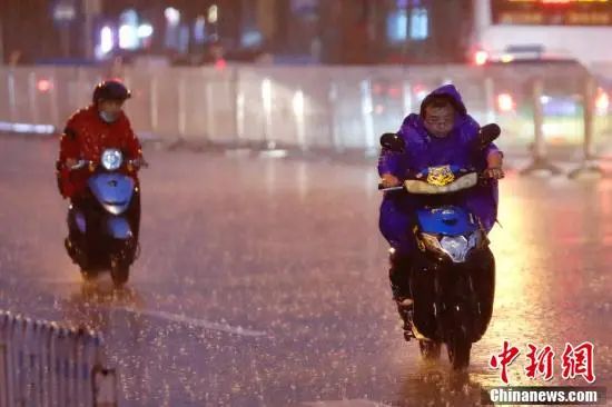 北京海淀区，市民冒雨出行。中新社记者 盛佳鹏 摄