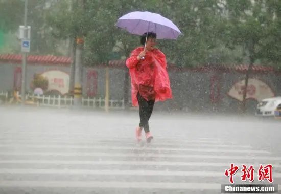 北京市海淀区，市民在雨中出行。中新社记者 蒋启明 摄