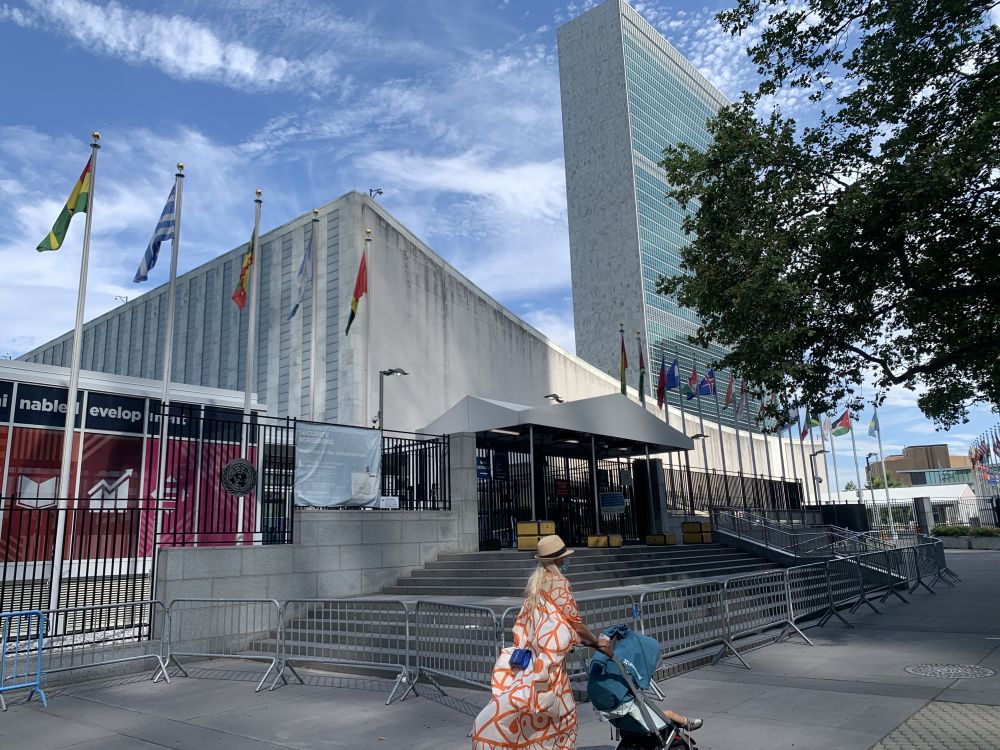  2020年7月20日，一名推童车的女子经过位于纽约的联合国总部游客入口处。新华社记者王建刚摄