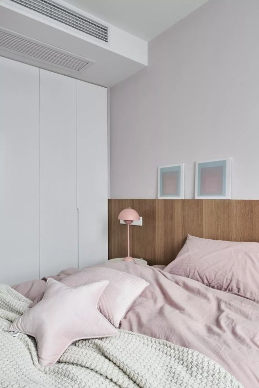 床左侧是嵌入式的白色衣柜,收纳能力很强,与墙体处于一个水平线上