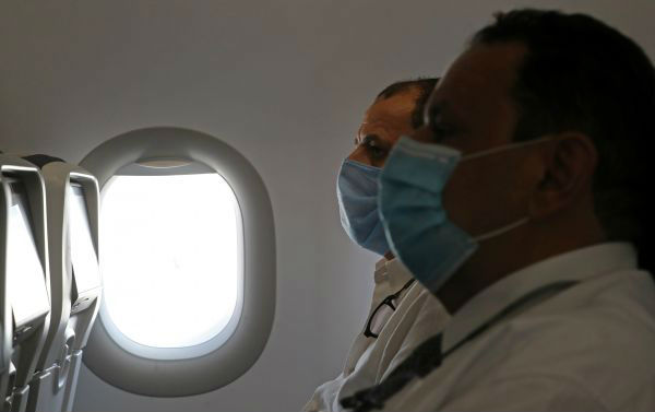 旅客们戴口罩乘坐飞机。新华社/路透