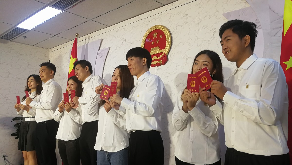 仪式上,4对新人拿到自己的结婚证后,面对庄严的国旗和国徽,一起宣读