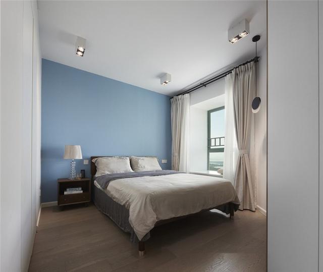 安静的天空蓝背景墙,与灰蓝的天丝床品一起打造了一个舒适的睡眠区.