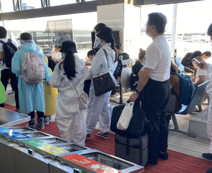 成田机场，穿防护服的中国人特别显眼