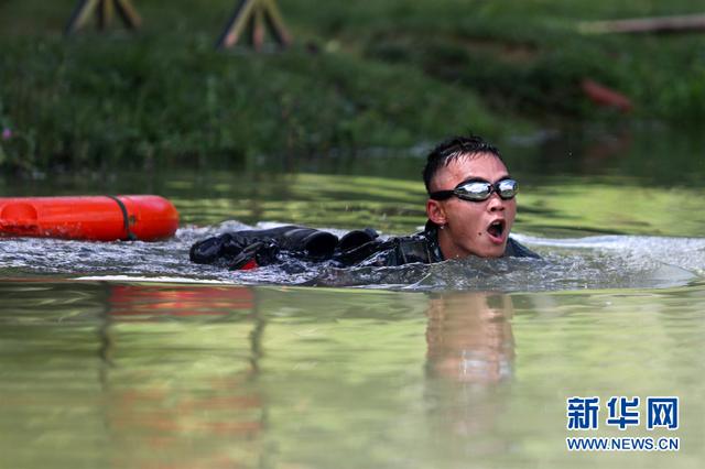 图为参赛队员参加个人全能比武时进行武装泅渡.新华网发(雷辙 摄)