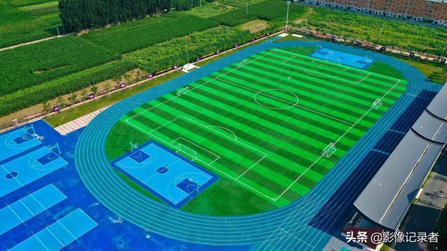 在校园东侧,是一座400米的标准体育场,蓝色跑道,绿色的足球场,到处