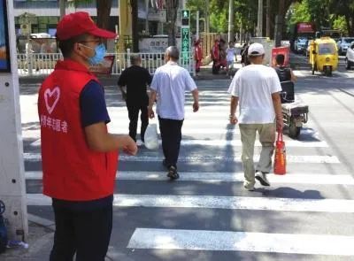 某市“创文”期间，志愿者在街头疏导交通。图源：网络