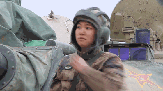 △下了坦克，她揉揉睫毛上的尘土，害羞地笑了