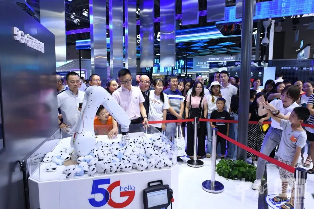 图为2019年智博会现场，民众排队体验5G远程控制隔空抓物 中新社记者 陈超 摄