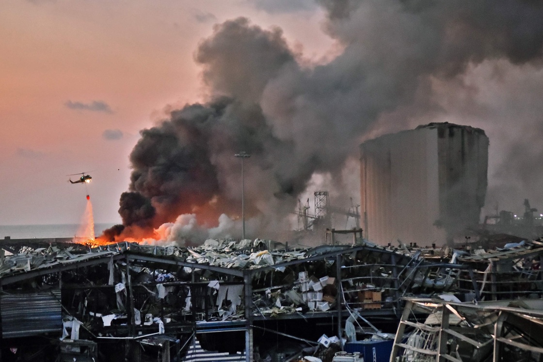 8月4日,一架直升机在黎巴嫩首都贝鲁特爆炸现场灭火。新华社/法新 图