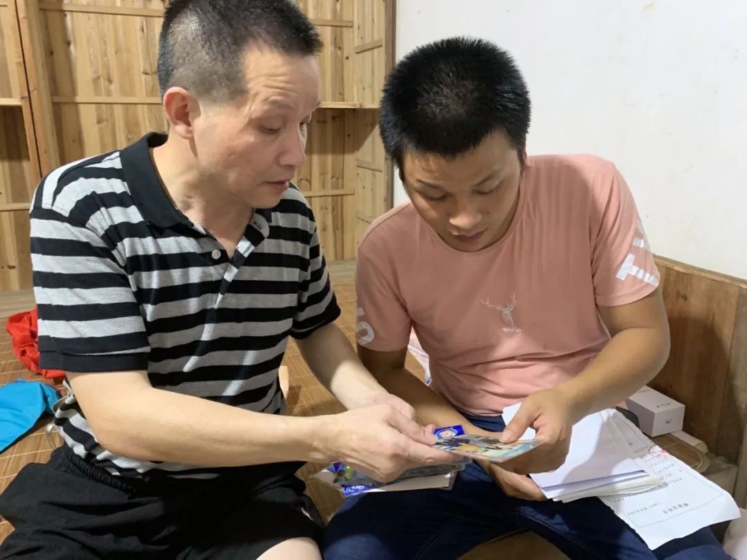  8月4日，张玉环给二儿子看他从狱中带出的家人照片。新京报记者张胜坡 摄