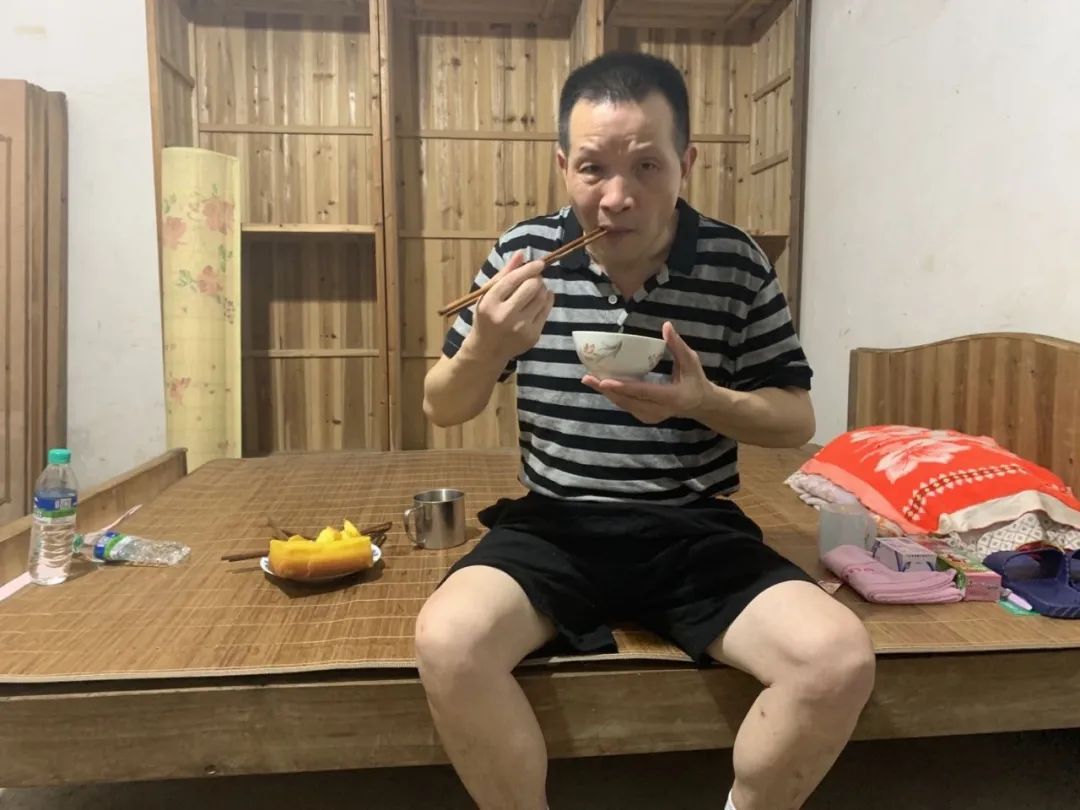  8月4日，张玉环在吃汤圆，床上有家人为他新买的洗漱用品和一部智能手机。新京报记者张胜坡 摄