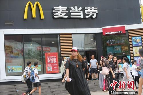 资料图：民众从国内一麦当劳门店前经过。中新社记者 张云 摄