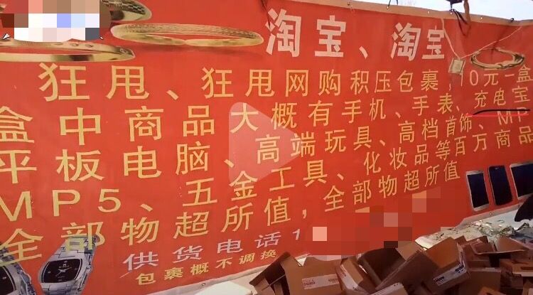 网友“迷路人亮子”发布的视频中，售卖“快递盲盒”摊位后的红色条幅下方写有供货电话。图片/视频截图