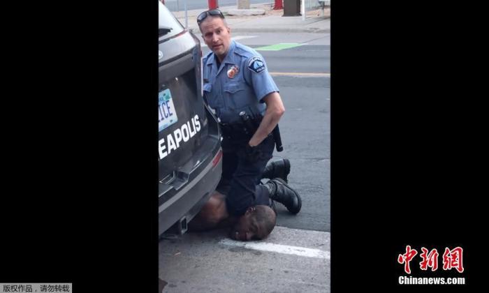 当地时间5月25日，美国明尼苏达州明尼阿波利斯市一名警察在逮捕非裔男子乔治·弗洛伊德时，将其按在地上，用膝盖顶住脖子。（视频截图）